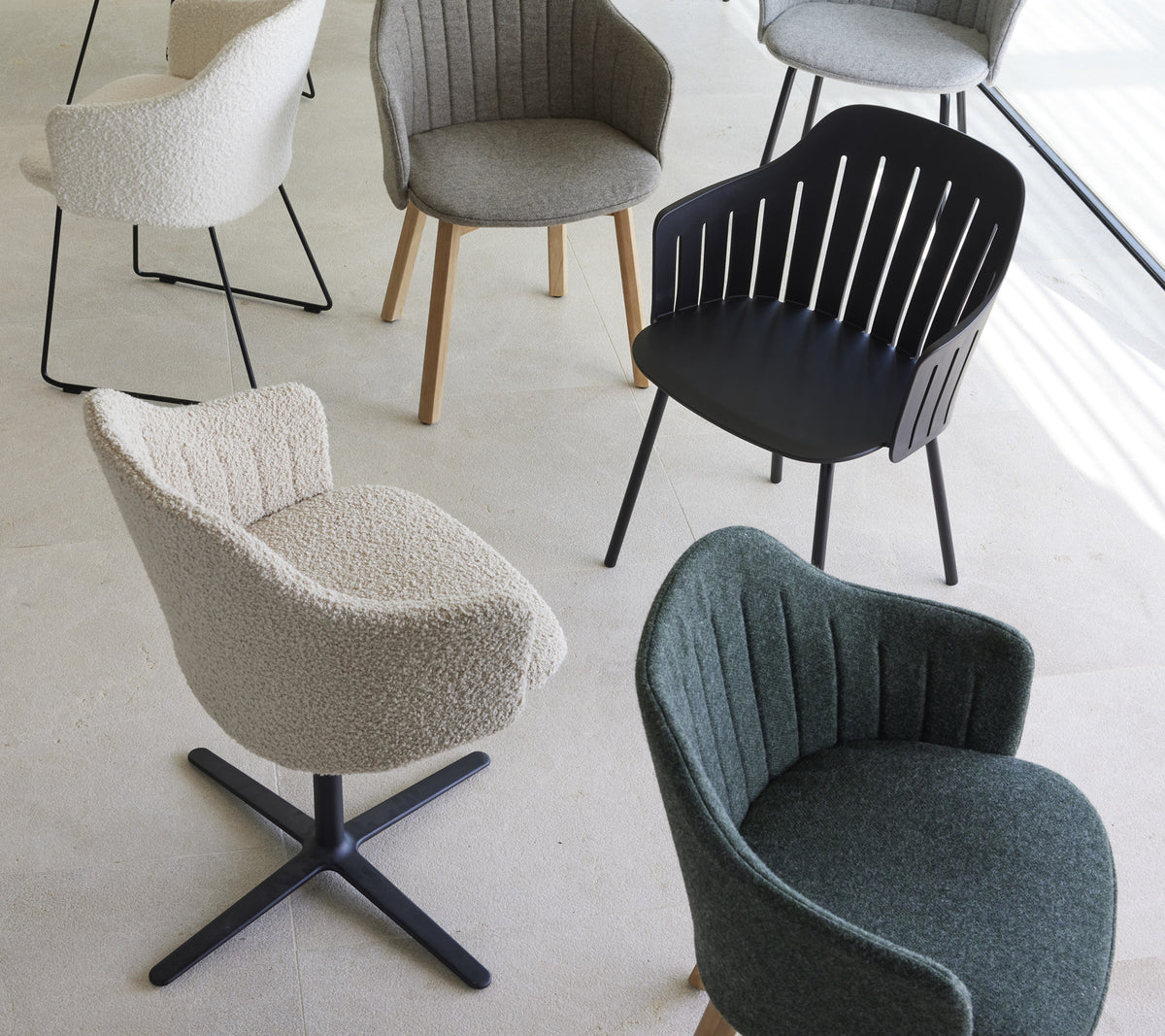 En samling stiliga stolar i olika designer och färger, med unika texturer och former, lämpliga för moderna bostadsutrymmen.
